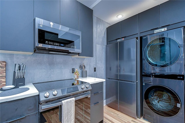 215 Central Ave Unit 2B, Saint Petersburg, FL 33701 - kitchen with stainless steel appliances, estacked washer and dryer, modern cabinets, and light countertops