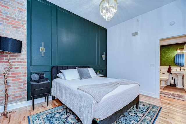 215 Central Ave Unit 2B, Saint Petersburg, FL 33701 - bedroom with light wood finished floors, baseboards, and a chandelier