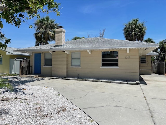 3207 S De Bazan Ave, St Pete Beach, FL 33706 - back of property with a chimney and a shingled roof