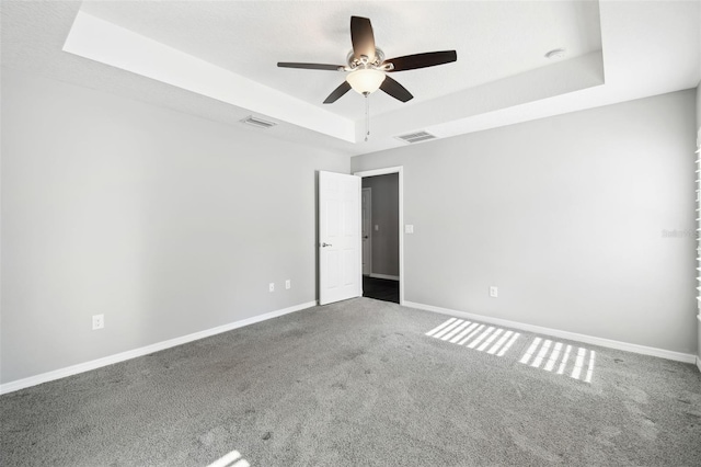 13227 Quigley Ave, Weeki Wachee, FL 34614 - carpeted spare room featuring a tray ceiling, a ceiling fan, and baseboards