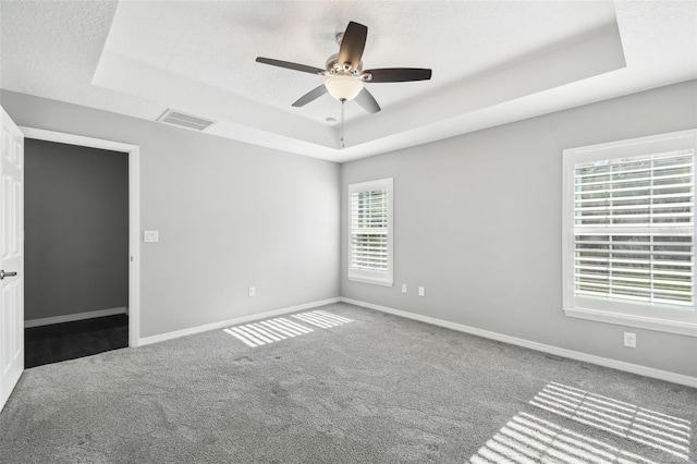 13227 Quigley Ave, Weeki Wachee, FL 34614 - spare room with a tray ceiling, carpet, baseboards, and ceiling fan