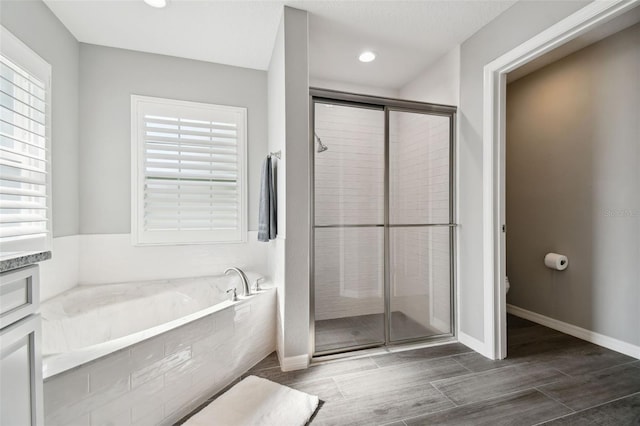 13227 Quigley Ave, Weeki Wachee, FL 34614 - full bath featuring a garden tub, a shower stall, toilet, wood finish floors, and recessed lighting