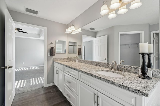 13227 Quigley Ave, Weeki Wachee, FL 34614 - full bath featuring double vanity, wood finished floors, baseboards, and a walk in closet