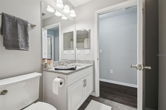 13227 Quigley Ave, Weeki Wachee, FL 34614 - bathroom with wood finished floors, vanity, toilet, and baseboards