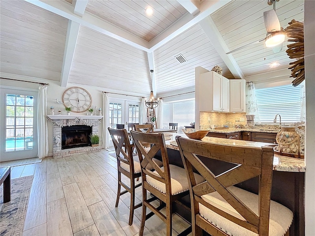 1445 Stonehenge Way, Palm Harbor, FL 34683 - kitchen featuring a fireplace, light stone countertops, a sink, wooden ceiling, and decorative backsplash