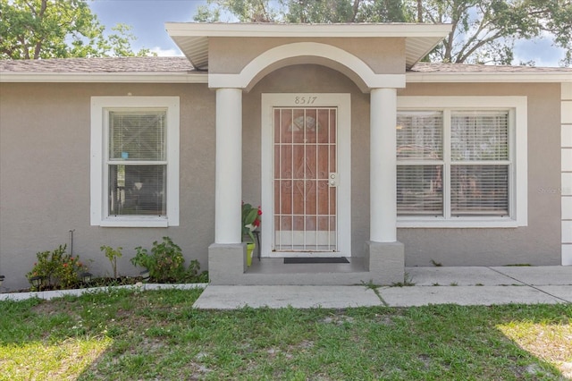 8517 N Branch Ave, Tampa, FL 33604 - doorway to property with stucco siding and a shingled roof