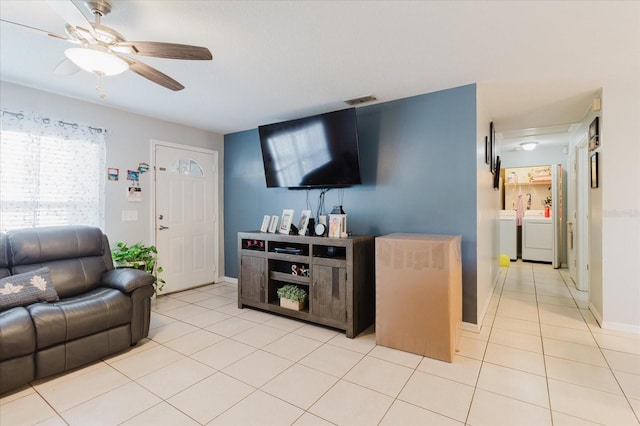 8517 N Branch Ave, Tampa, FL 33604 - living area with light tile patterned floors, ceiling fan, washing machine and clothes dryer, and baseboards