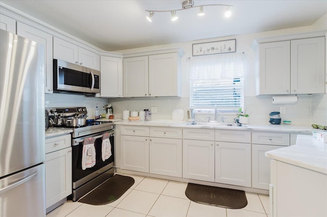 8517 N Branch Ave, Tampa, FL 33604 - kitchen featuring stainless steel appliances, a sink, light tile patterned flooring, light countertops, and backsplash