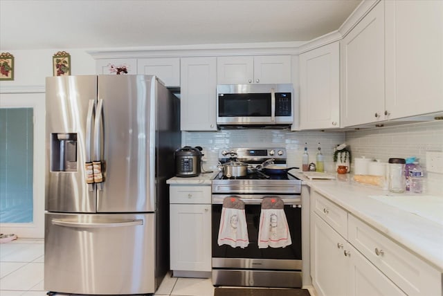 8517 N Branch Ave, Tampa, FL 33604 - kitchen with stainless steel appliances, backsplash, light tile patterned floors, and white cabinets