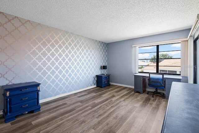 609 Lively Dr Unit B, Sun City Center, FL 33573 - unfurnished office with wallpapered walls, a textured ceiling, an accent wall, dark wood finished floors, and baseboards