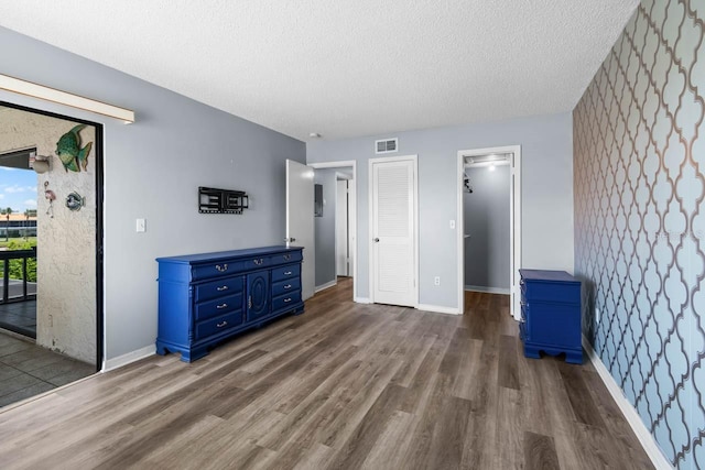 609 Lively Dr Unit B, Sun City Center, FL 33573 - unfurnished bedroom with dark wood-type flooring, access to outside, a textured ceiling, a closet, and baseboards