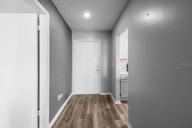 609 Lively Dr Unit B, Sun City Center, FL 33573 - hall featuring wood finished floors, a textured ceiling, and baseboards
