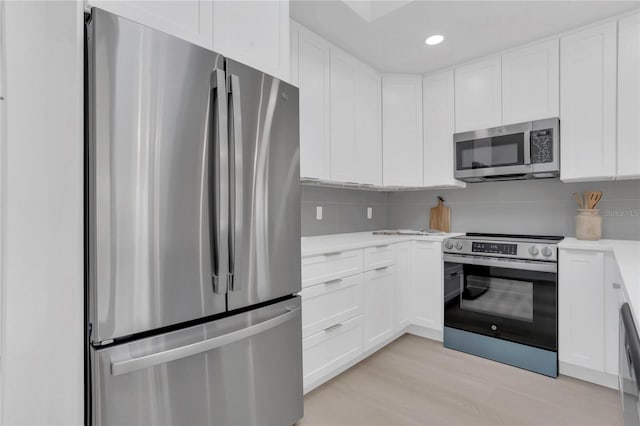 323 48th St NW, Bradenton, FL 34209 - kitchen featuring appliances with stainless steel finishes, light countertops, white cabinets, tasteful backsplash, and recessed lighting