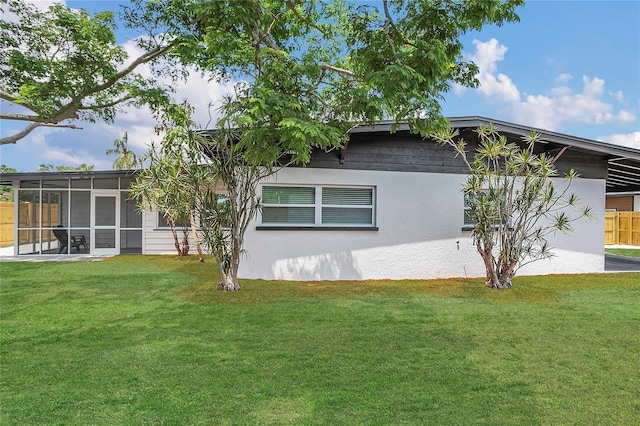 323 48th St NW, Bradenton, FL 34209 - view of side of home featuring a yard, a sunroom, and stucco siding