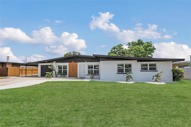 323 48th St NW, Bradenton, FL 34209 - rear view of property featuring concrete driveway, a garage, an attached carport, and stucco siding