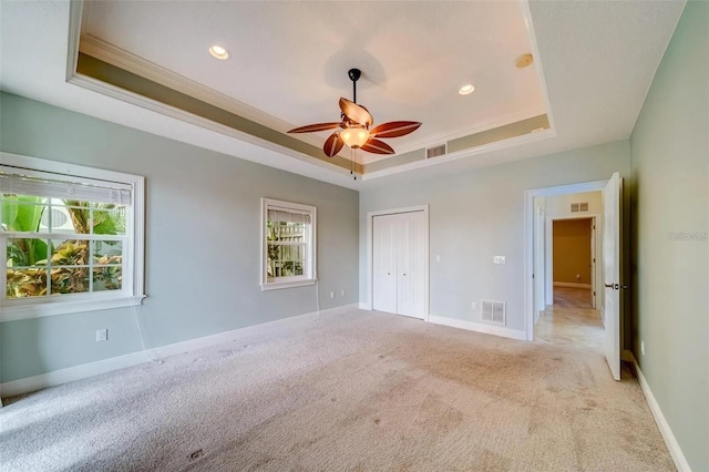 803 Harbor Dr, Belleair Beach, FL 33786 - unfurnished bedroom featuring a raised ceiling, light colored carpet, crown molding, recessed lighting, and a closet
