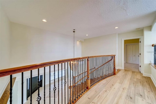 803 Harbor Dr, Belleair Beach, FL 33786 - corridor featuring wood-type flooring, recessed lighting, an upstairs landing, a textured ceiling, and baseboards