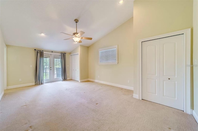 803 Harbor Dr, Belleair Beach, FL 33786 - unfurnished bedroom featuring vaulted ceiling, multiple closets, french doors, light carpet, and access to exterior