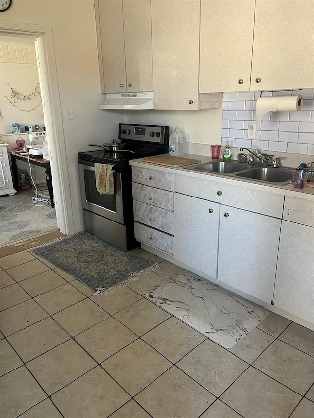 6220 Massachusetts Ave, New Port Richey, FL 34653 - kitchen with stainless steel electric range oven, under cabinet range hood, a sink, tasteful backsplash, and white cabinetry