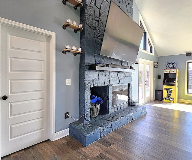 1608 20th Ave W, Palmetto, FL 34221 - living area with lofted ceiling, a stone fireplace, wood finished floors, and baseboards