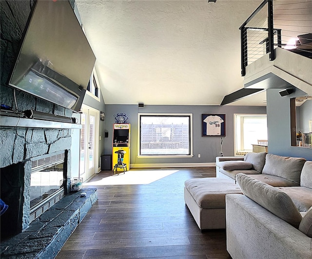 1608 20th Ave W, Palmetto, FL 34221 - living area with plenty of natural light, dark wood-type flooring, a stone fireplace, high vaulted ceiling, and a textured ceiling