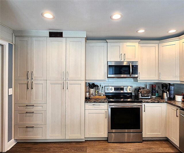 1608 20th Ave W, Palmetto, FL 34221 - kitchen with appliances with stainless steel finishes, dark wood-style flooring, decorative backsplash, dark stone countertops, and recessed lighting