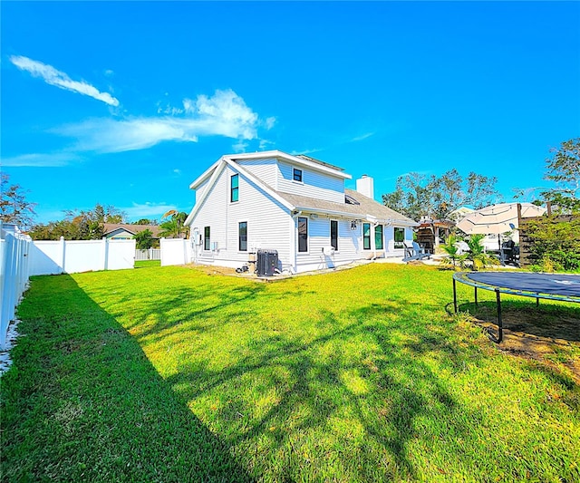 1608 20th Ave W, Palmetto, FL 34221 - rear view of house with a trampoline, central AC, and a chimney