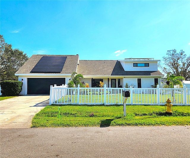 1608 20th Ave W, Palmetto, FL 34221 - traditional-style home with a garage, roof mounted solar panels, driveway, a fenced front yard, and roof with shingles