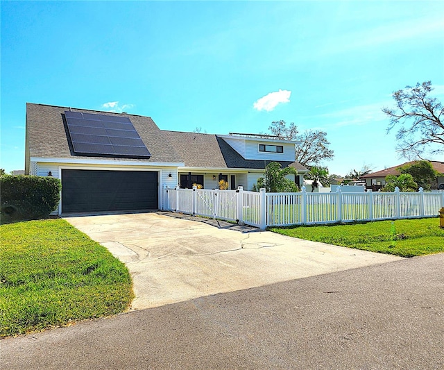 1608 20th Ave W, Palmetto, FL 34221 - view of front of house with roof mounted solar panels, concrete driveway, a gate, a shingled roof, and a garage