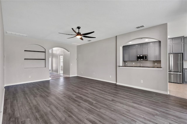 7732 Bulls Head Dr, Wesley Chapel, FL 33545 - unfurnished living room with a ceiling fan, arched walkways, and wood finished floors