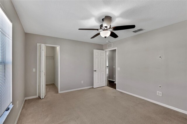 7732 Bulls Head Dr, Wesley Chapel, FL 33545 - unfurnished bedroom with light carpet, baseboards, a walk in closet, and a closet