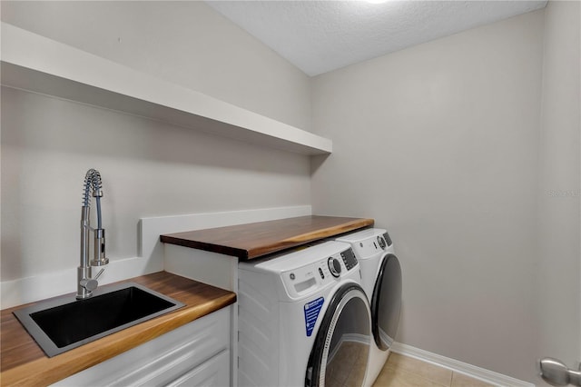 7732 Bulls Head Dr, Wesley Chapel, FL 33545 - laundry room featuring washing machine and clothes dryer, baseboards, light tile patterned floors, and a textured ceiling