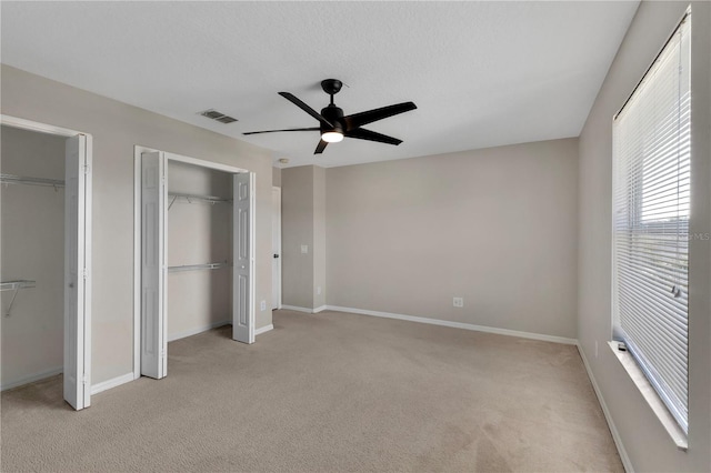 7732 Bulls Head Dr, Wesley Chapel, FL 33545 - unfurnished bedroom featuring multiple closets, light colored carpet, and baseboards