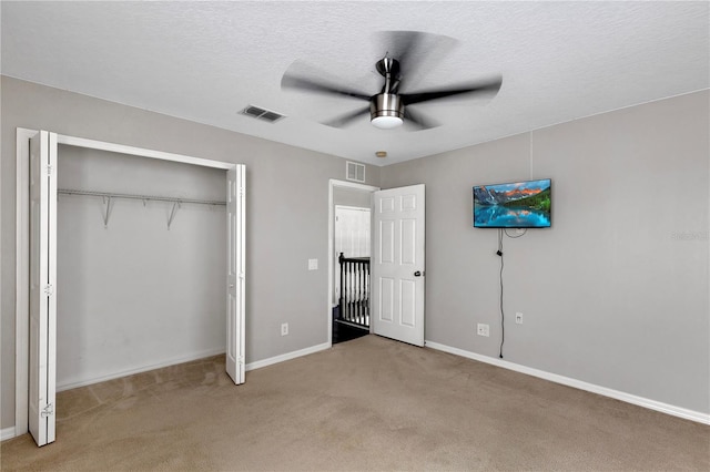 7732 Bulls Head Dr, Wesley Chapel, FL 33545 - unfurnished bedroom with light colored carpet, a closet, baseboards, a ceiling fan, and a textured ceiling