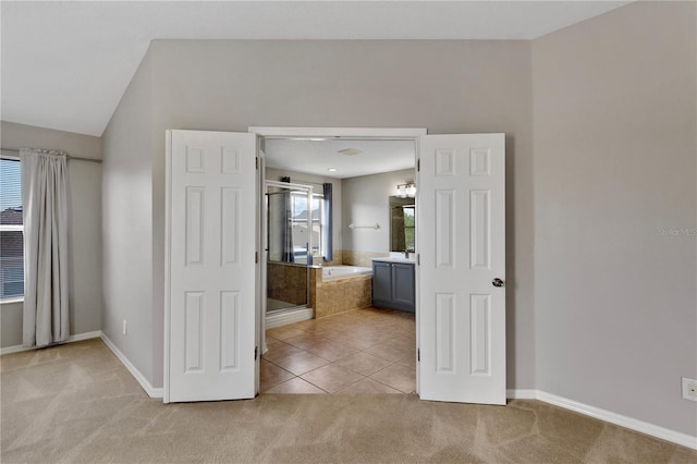 7732 Bulls Head Dr, Wesley Chapel, FL 33545 - unfurnished bedroom featuring light carpet, ensuite bathroom, baseboards, and light tile patterned floors