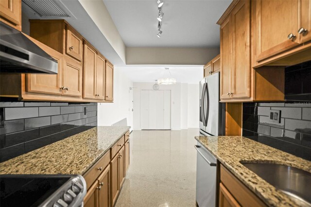 10355 Paradise Blvd Unit 1003, Treasure Island, FL 33706 - kitchen featuring wall chimney range hood, tasteful backsplash, light stone countertops, and a chandelier