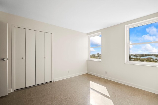 10355 Paradise Blvd Unit 1003, Treasure Island, FL 33706 - unfurnished bedroom with multiple windows, baseboards, and a closet