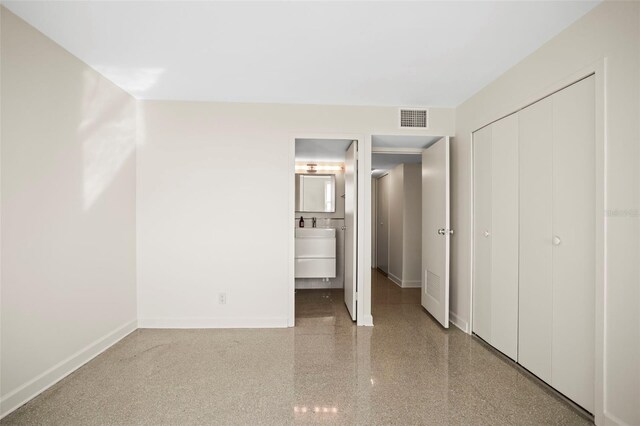 10355 Paradise Blvd Unit 1003, Treasure Island, FL 33706 - unfurnished bedroom with baseboards, a closet, and connected bathroom