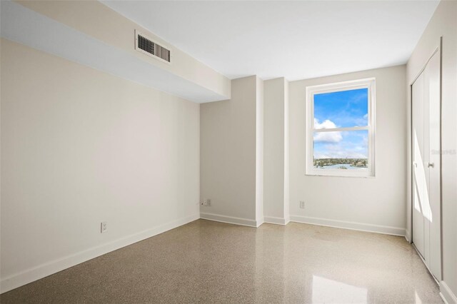 10355 Paradise Blvd Unit 1003, Treasure Island, FL 33706 - unfurnished bedroom with baseboards and dark aggregate flooring