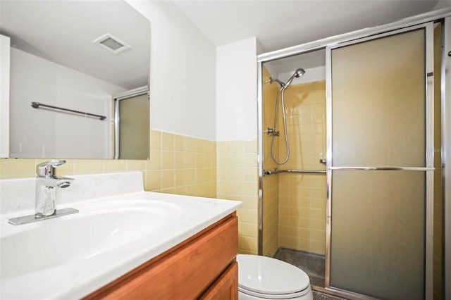 10355 Paradise Blvd Unit 1003, Treasure Island, FL 33706 - bathroom featuring vanity, a stall shower, toilet, tile walls, and wainscoting