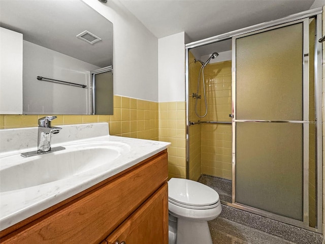 10355 Paradise Blvd Unit 1003, Treasure Island, FL 33706 - bathroom with vanity, toilet, a shower stall, tile walls, and a wainscoted wall