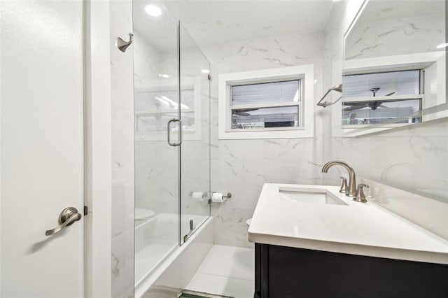 5005 W Evelyn Dr, Tampa, FL 33609 - bathroom with vanity, toilet, tile walls, and enclosed tub / shower combo