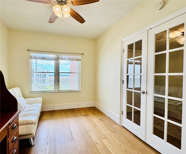 1586 Gulf Blvd Unit 2502, Clearwater, FL 33767 - living area with light wood finished floors, french doors, a ceiling fan, and a textured ceiling