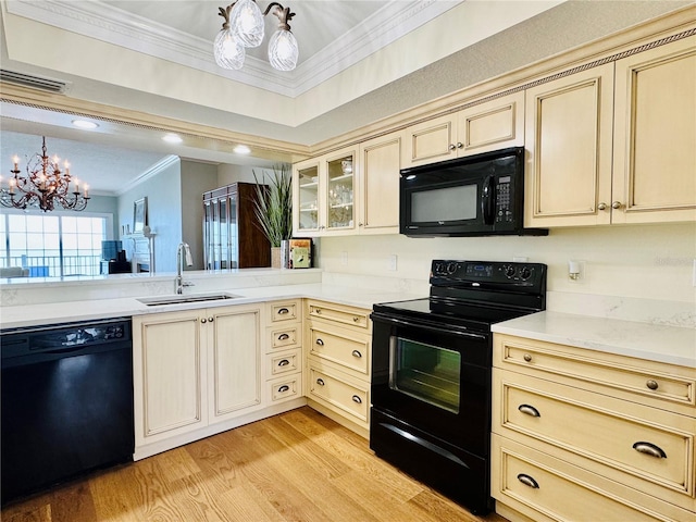 1586 Gulf Blvd Unit 2502, Clearwater, FL 33767 - kitchen with black appliances, cream cabinetry, crown molding, and a chandelier