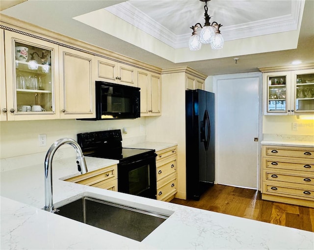 1586 Gulf Blvd Unit 2502, Clearwater, FL 33767 - kitchen with black appliances, a chandelier, cream cabinets, crown molding, and dark wood-style flooring