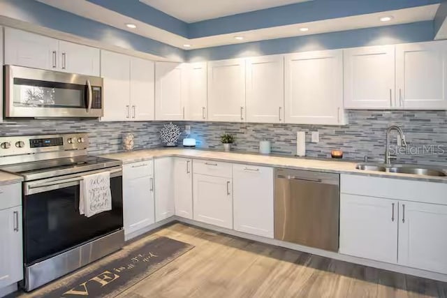 5701 Bahia Del Mar Cir Unit 108, Saint Petersburg, FL 33715 - kitchen featuring stainless steel appliances, a sink, light countertops, recessed lighting, and white cabinets