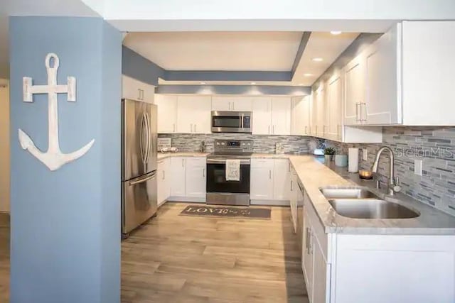 5701 Bahia Del Mar Cir Unit 108, Saint Petersburg, FL 33715 - kitchen with stainless steel appliances, a sink, light countertops, white cabinets, and recessed lighting