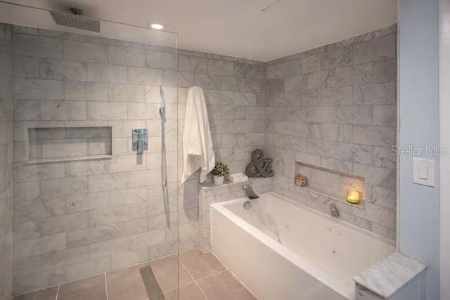 5701 Bahia Del Mar Cir Unit 108, Saint Petersburg, FL 33715 - bathroom featuring a bath, tile patterned floors, a tile shower, and tile walls