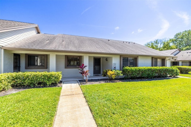 2510 Laurelwood Dr Unit 5B, Clearwater, FL 33763 - view of front facade featuring a front yard and roof with shingles