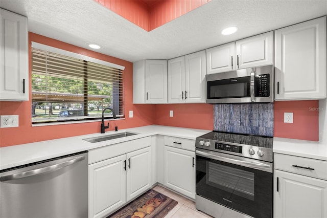 2510 Laurelwood Dr Unit 5B, Clearwater, FL 33763 - kitchen featuring appliances with stainless steel finishes, a sink, light countertops, white cabinets, and a textured ceiling